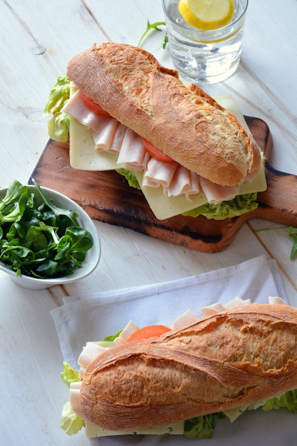 Panino con formaggio e prosciutto di tacchino servito con lattuga e pomodoro