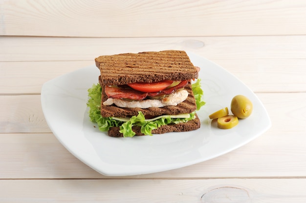 Sandwich with chicken and bacon on plate