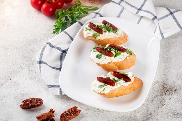 Sandwich with cream cheese and dried tomatoes on a plate