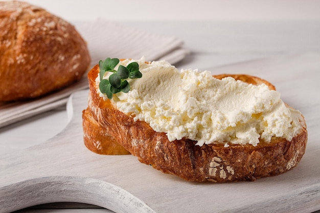 Foto panino con crema di formaggio fatto in casa su un tagliere in stile rustico nessuna colazione a fuoco selettiva di persone