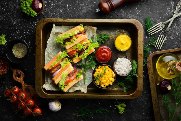 Sandwich with cutlet cheese and lettuce on a black stone background Street food Top view Free copy space