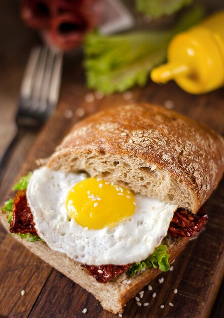 Sandwich with dark bread, dried tomatoes and egg.