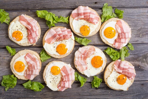 Sandwich with eggs salad and bacon on wooden table top view