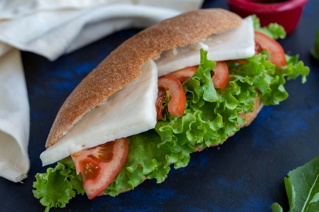 Sandwich with feta tomato lettuce arugula among wholewheat bread quick snack tasty sandwich