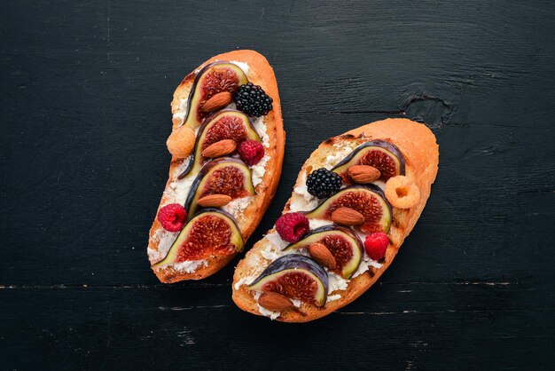 Sandwich with figs wild berries and cheese On the old background Dessert Free space for text Top view