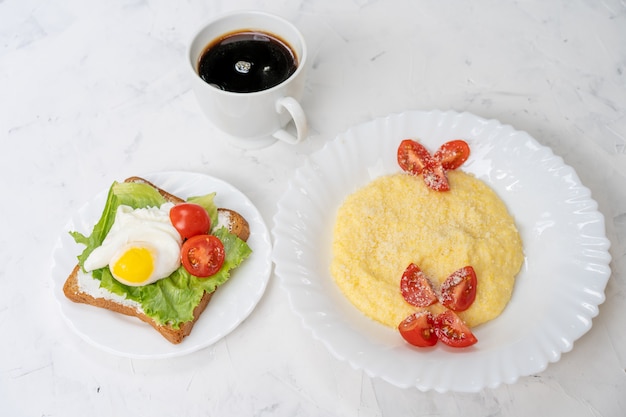 Photo sandwich with fried eggs salad and tomato on plate  white  with copyspace