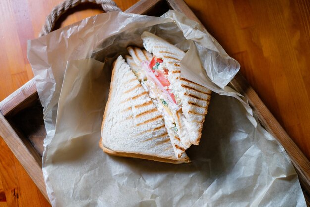 Sandwich with ham and vegetables on parchment paper Delicious lunch