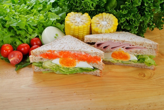 Sandwich with ham on wood background