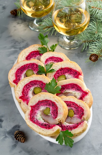 Photo sandwich with herring fillet, onion, pickled cucumber, cream cheese and beetroot. holiday appetizer