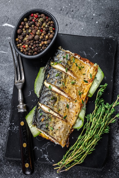 Sandwich with mackerel fish, cucumber and mustard. Black background. Top view.