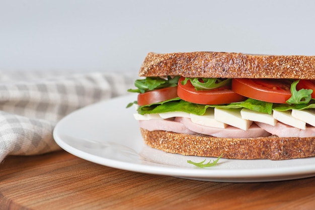 Sandwich with meat and cheese on a white plate