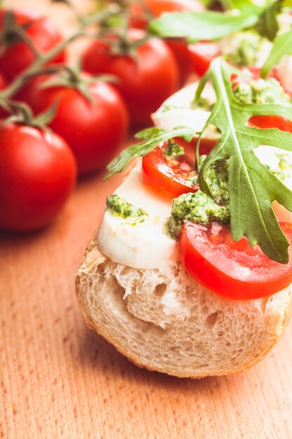 Sandwich with mozzarella, tomato, arugula and pesto