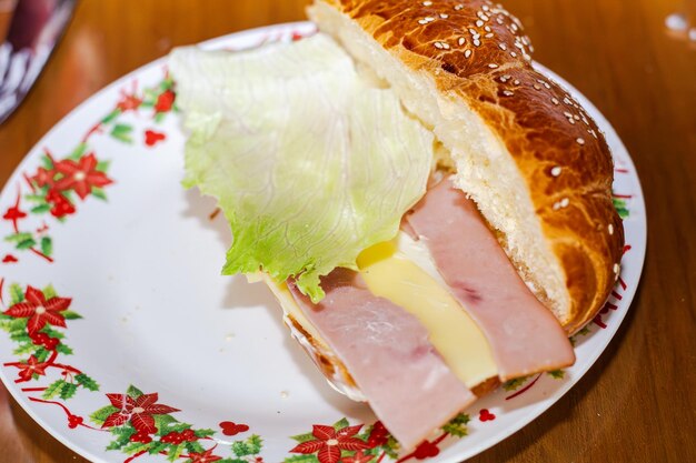 Photo sandwich with open bread with cheese ham lettuce and mayonnaise on a plate on a table for breakfast