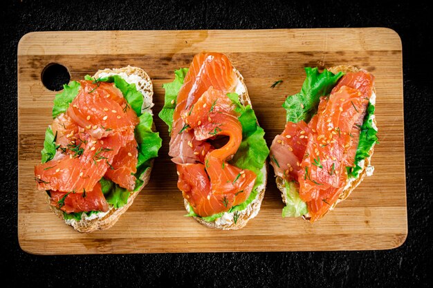 Sandwich with pieces of salmon on a cutting board