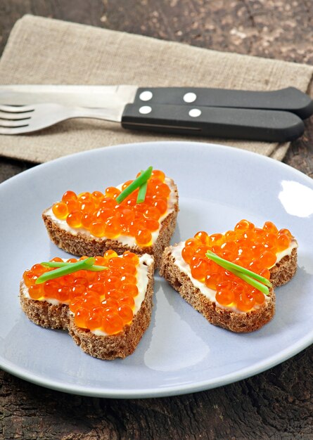 Foto panino con caviale rosso a forma di cuore