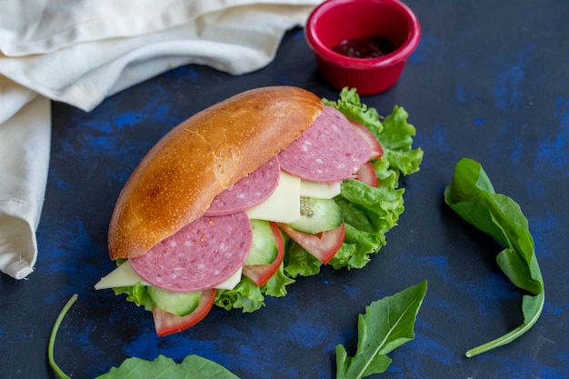 Sandwich with salami cheddar tomato cucumber lettuce arugula in bread quick snack delicious sandwich