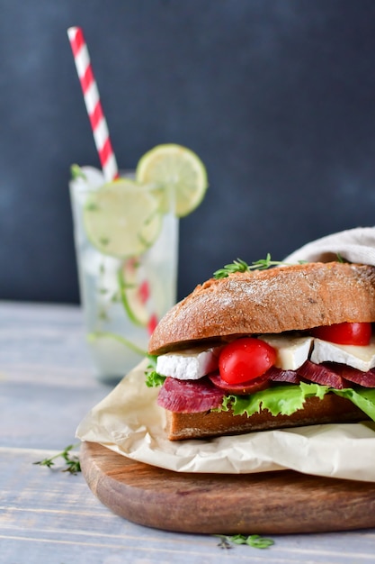 sandwich with salami and cheese on a wooden plate