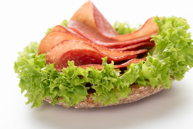 Sandwich with salami sausage on white background.