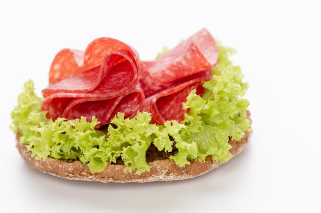 Sandwich with salami sausage on white background.