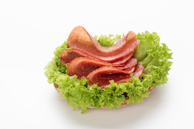 Sandwich with salami sausage on white background.