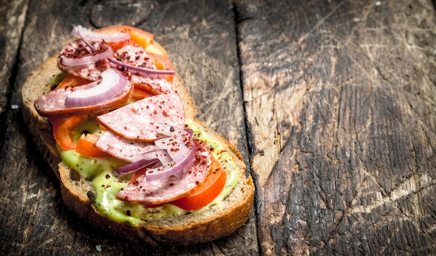 Sandwich with salami, tomatoes and onions on fresh bread.