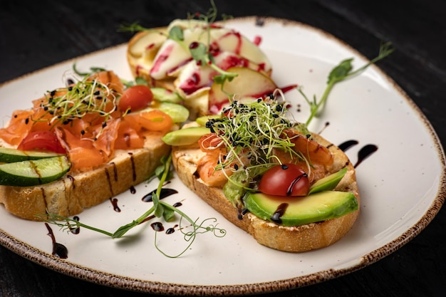 sandwich with salmon, avocado, tomato and cheese. healthy breakfast.