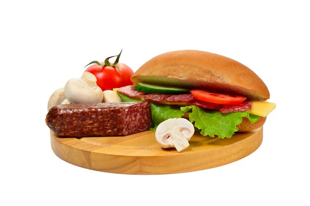 Sandwich with sausage and vegetables on cutting board isolated on white background