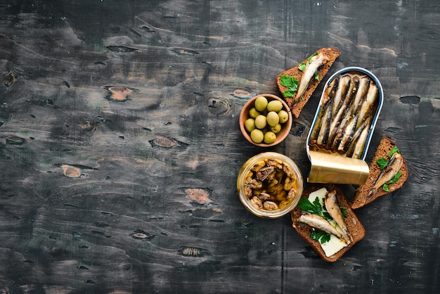 Sandwich with Sprat Sprat in oil On a black background top view Free copy space