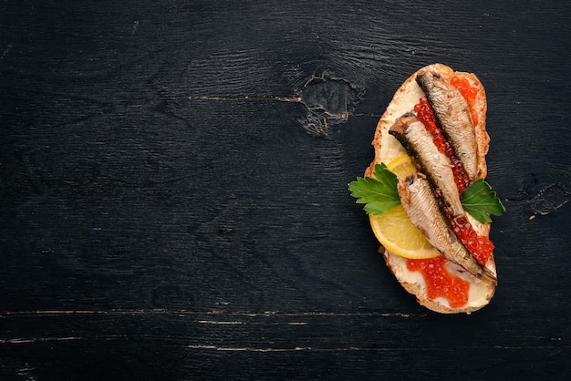 Сэндвич со шпротами и луком икры на деревянном фоне Вид сверху Копией пространства
