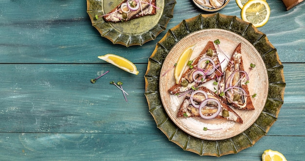 Sandwich with sprats onions capers and microgreens Danish cuisine Long banner format top view