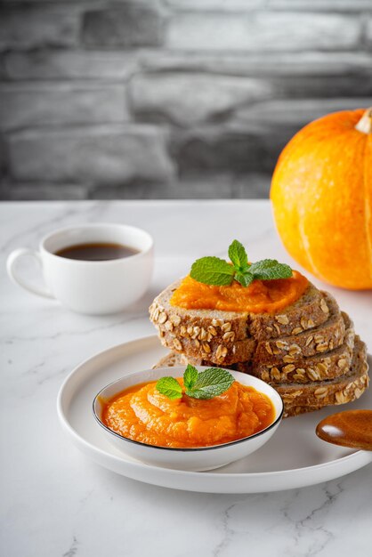 Sandwich with tasty pumpkin jam on table