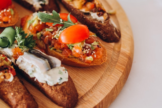 Sandwich with trout, cherry tomatoes and lettuce. plate of snacks.