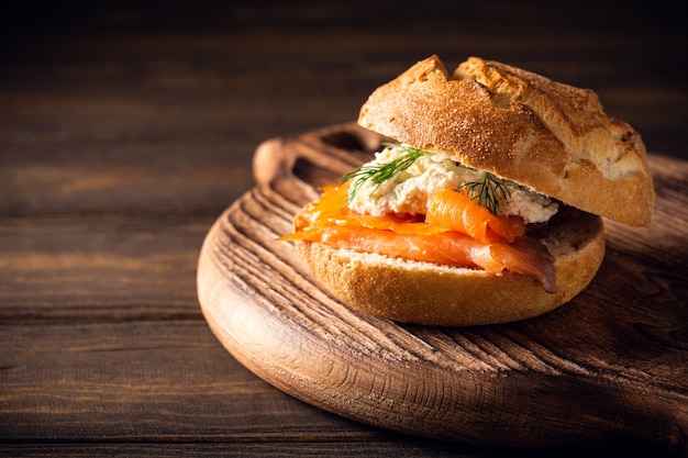 Sandwiche with salmon and herb butter on old wooden table