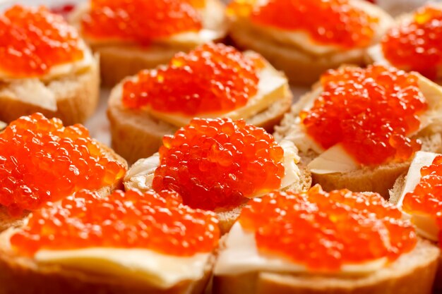 Sandwiches of bread and butter with red caviar