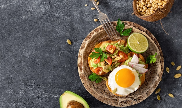 Foto panini a colazione con purea di avocado, uovo fritto e verdure