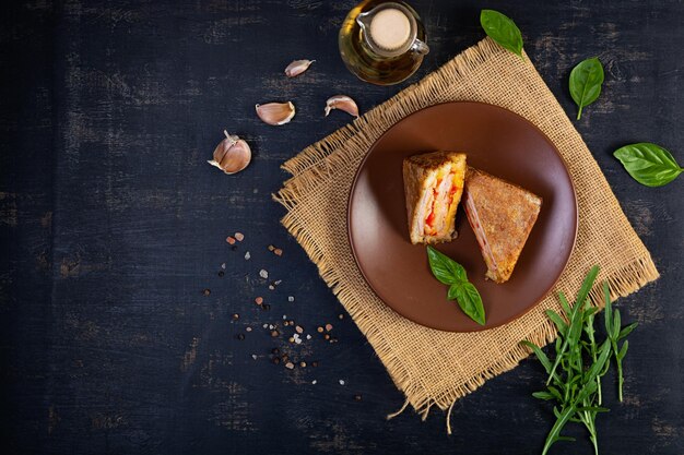 Photo sandwiches fried in breadcrumbs with ham cheese and tomatoes