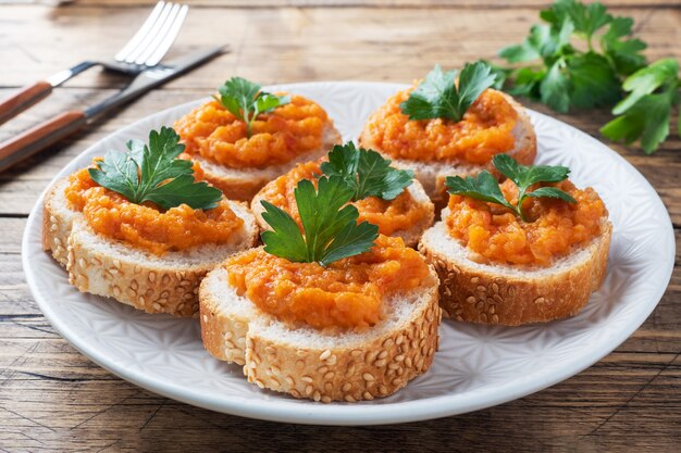 Sandwiches met brood courgette kaviaar tomaten uien. zelfgemaakte vegetarische gerechten. ingeblikte gestoofde groente. houten oppervlak