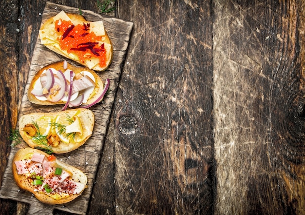 Sandwiches met champignons, salami, rode kaviaar en verse groenten op geroosterd brood