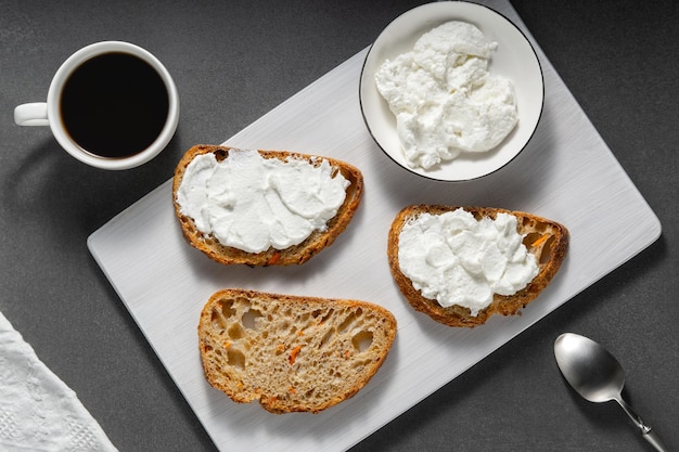 Sandwiches met kaas en brood met wortels op een grijze tafel.