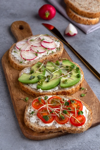 Sandwiches met microgreens en groenten op een snijplank op een betonnen ondergrond