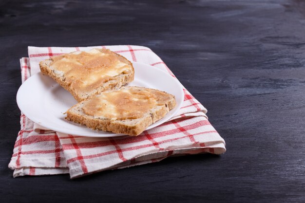 Sandwiches met pollock ree op een witte plaat, op een zwarte achtergrond