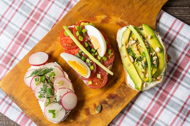 사진 냅킨 배경 위에 커팅 보드에 샌드위치 또는 타파스. 점심 또는 아침 식사를위한 건강식.