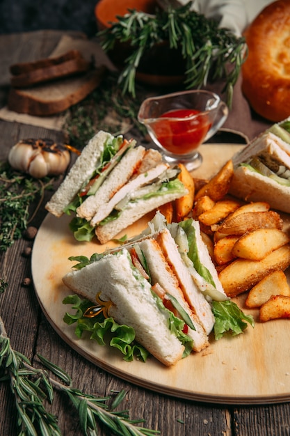 Sandwiches set with red sauce and rustic potato wedges