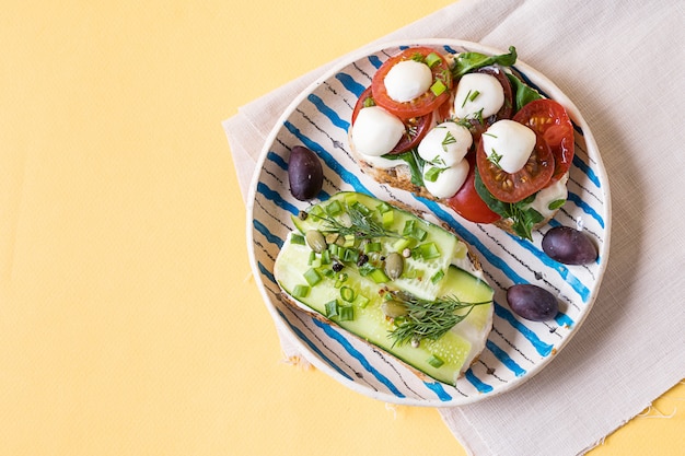 Sandwiches or tapas with bread , cream cheese, vegetable and tasty toppings. 