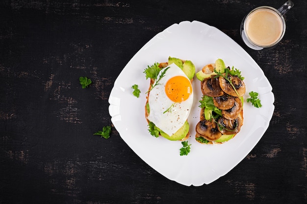 Sandwiches with avocado fried egg and mushrooms for healthy breakfast or snack Top view above