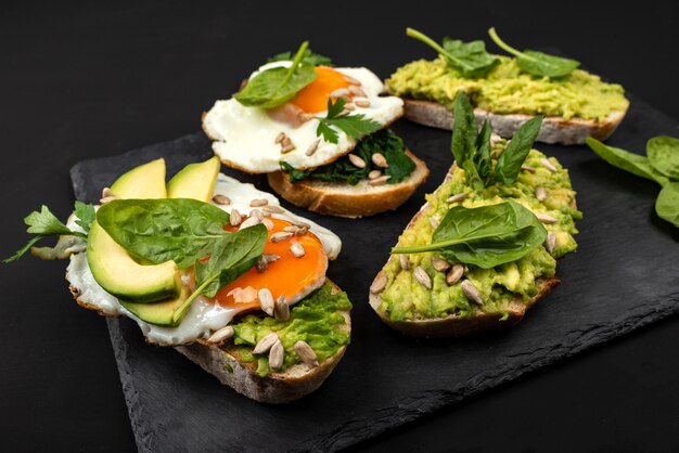 Sandwiches with avocado, spinach and fried eggs 