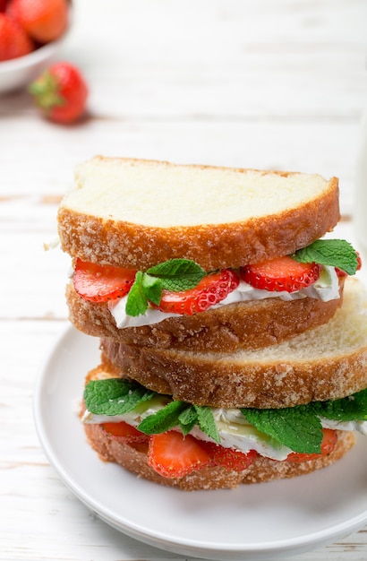 Sandwiches with brie cheese, strawberries and mint