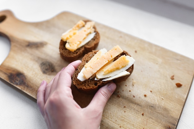 チーズのサンドイッチ。朝食に。マルチカラープレート。ボード。自家製の朝食。白いテーブルで朝食のチーズサンドイッチ