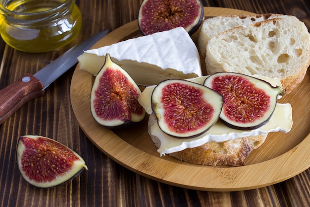 Panini con formaggio e fichi sul tagliere marrone