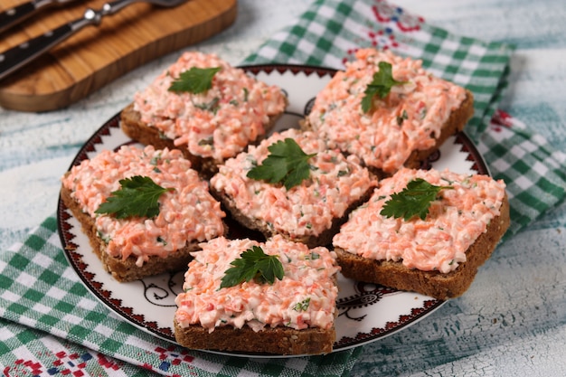 Sandwiches with crab sticks and carrots on a plate